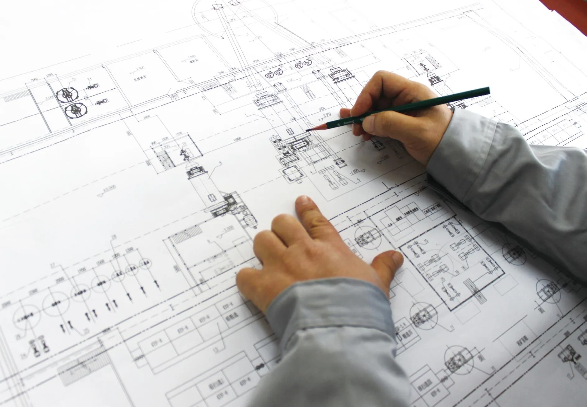 Engineers reviewing a mineral processing flowsheet drawing across plant design documents